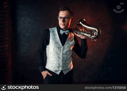 Male jazz man posing with saxophone. Jazz-man with sax concept. Saxophonist with classical brass band instrument