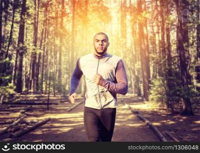 Male jogger on morning workout in the forest. Runner in sportswear on training outdoor. Jogging or running