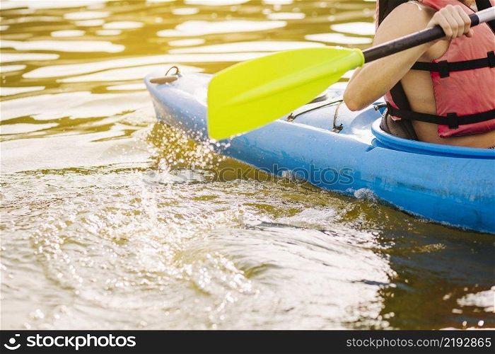 male kayaking with paddle lake
