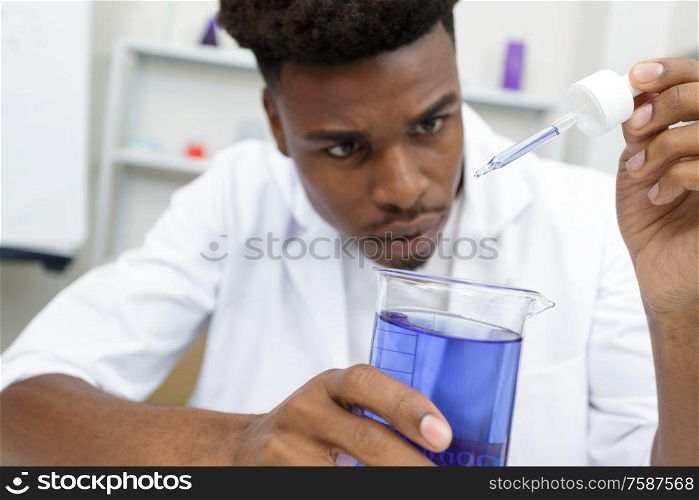 male lab assistant studying blood sample for analysis