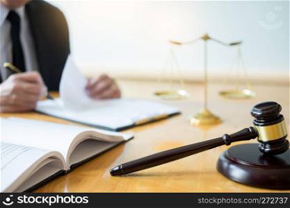 Male lawyer working with contract papers and reading law book in a courtroom, justice and law concept while presiding over trial