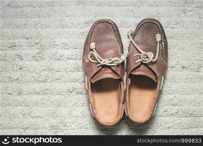 Male leather shoes on carpet, brown, top view,