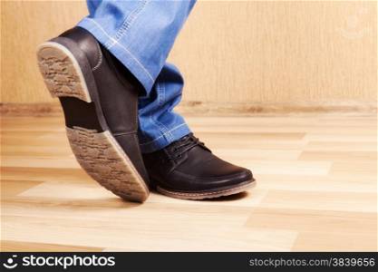 male legs in jeans and shoes in interior