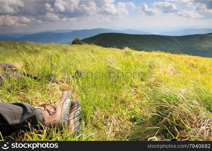 Male legs of resting tourist traveler in the beautiful mountain landscape. Travel and tourism.