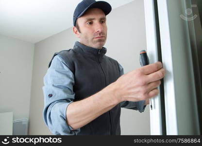 male lockpicker fixing door handle at home