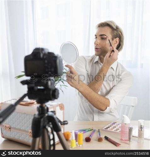 male make up look looking into mirror