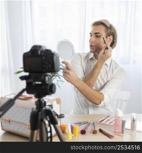 male make up look looking into mirror