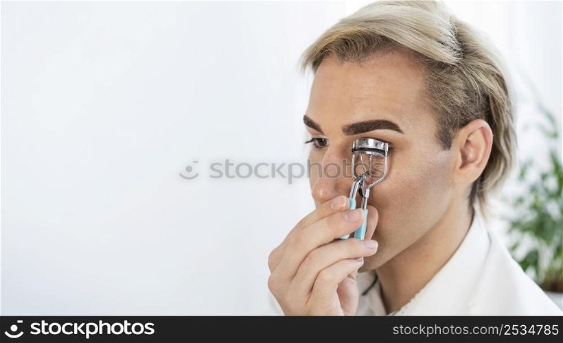 male make up look using eyelash curler
