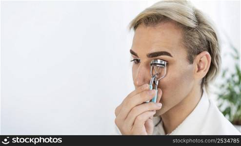 male make up look using eyelash curler