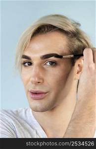 male make up look using his eyebrow brush