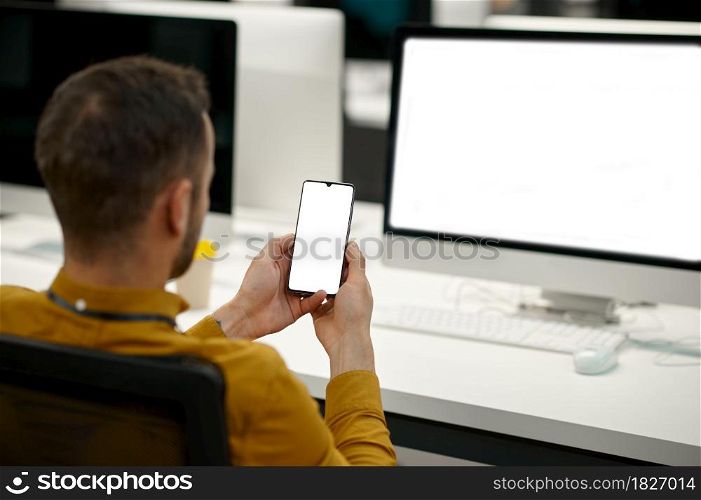 Male manager using phone on his workplace, idea developing in IT office. Professional worker, planning or brainstorming. Successful businessman works in modern company. Male manager using phone in IT office