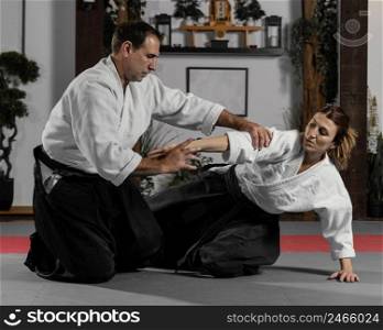 male martial arts instructor female trainee practicing