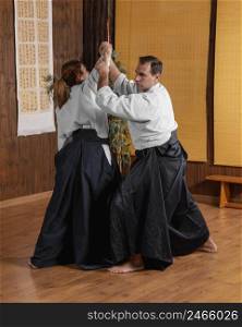 male martial arts instructor practice hall training with female trainee
