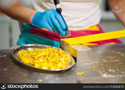 Male master hands in gloves, caramel making process. Candy preparation in pastry shop. Master hands in gloves, caramel making process