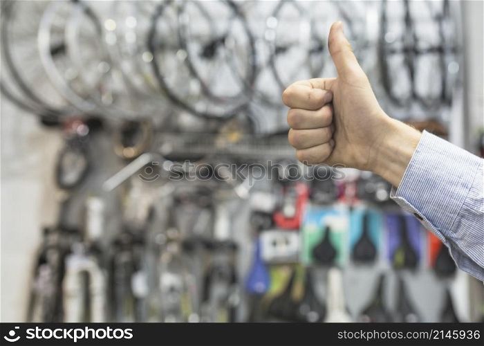 male mechanic gesturing thumbs up bicycle workshop
