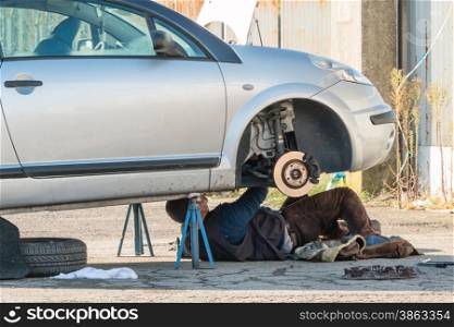 Male mechanic working on a car