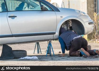 Male mechanic working on a car
