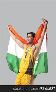 Male medalist celebrating victory with Indian flag against gray background