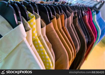 Male men&rsquo;s shirts on hangers on a shop rail