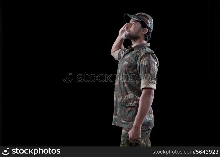 Male military soldier saluting over black background