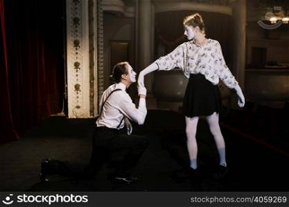 male mime artist kissing female mime s hand stage