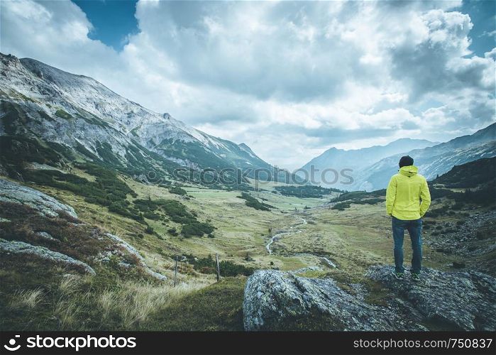Male mountain climber with backpack is enjoying the view