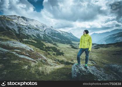 Male mountain climber with backpack is enjoying the view