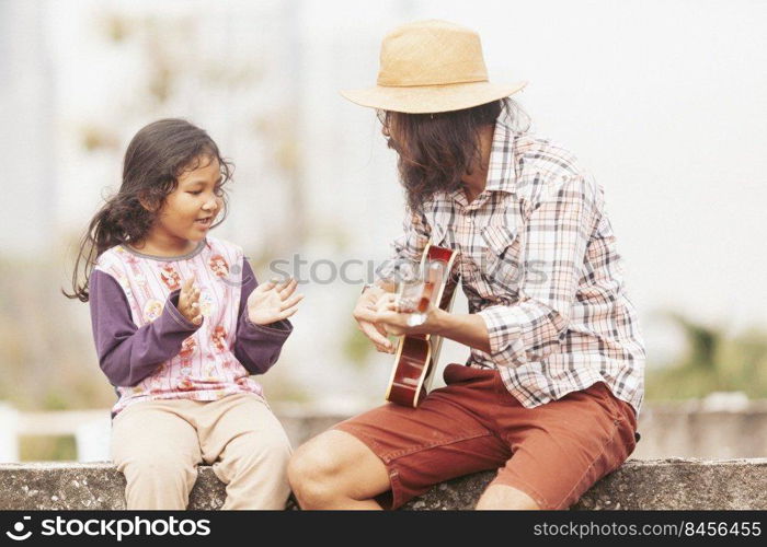 male musician playing guitar and have girls join in singing with fun