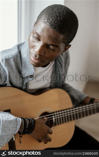 male musician playing guitar bed