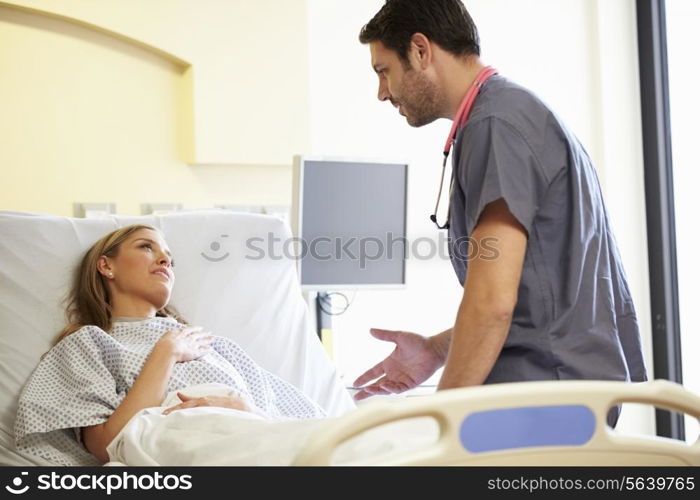 Male Nurse Talking With Female Patient In Hospital Room