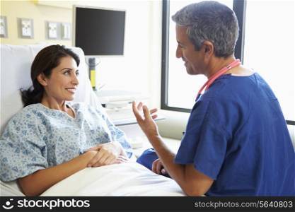 Male Nurse Talking With Female Patient In Hospital Room