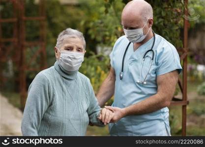 male nursing holding senior woman s hand help her walk