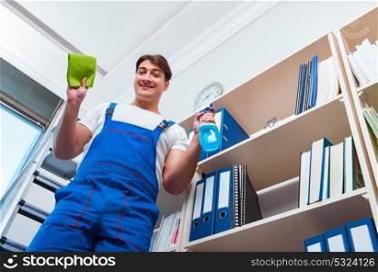 Male office cleaner cleaning shelves in office