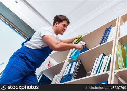 Male office cleaner cleaning shelves in office