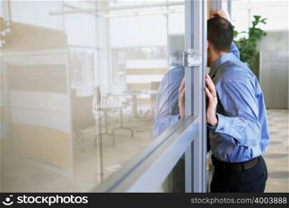 Male office worker leaning in doorway