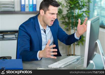 male office worker shouting on the computer screen