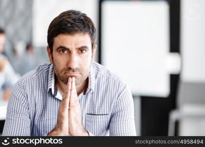 Male office worker sitting at desk. Young businessman sitting at desk in office