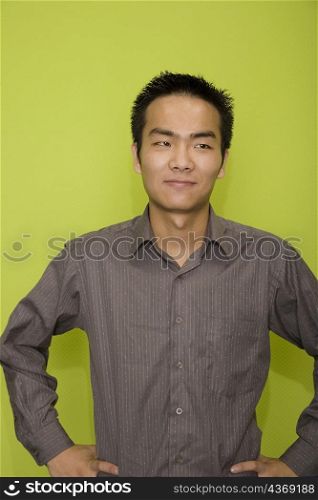 Male office worker standing with arms akimbo