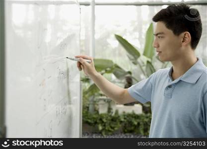 Male office worker writing on a whiteboard