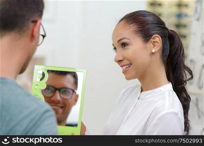 male optical client looking at himself in the mirror