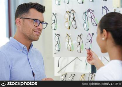 male optician patient and difficult choice of glasses