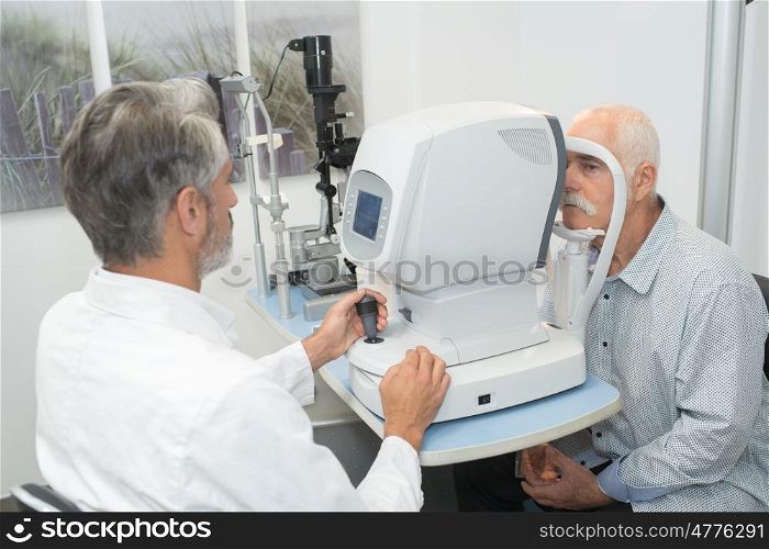 male optometrist doing sight testing for an old patient
