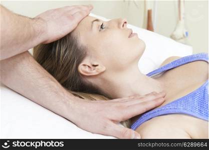 Male Osteopath Treating Female Patient With Neck Problem