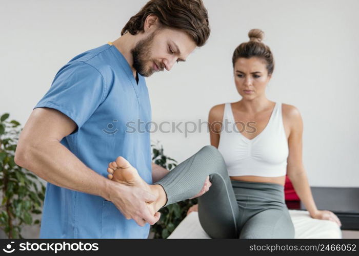 male osteopathic therapist checking female patient s leg movement