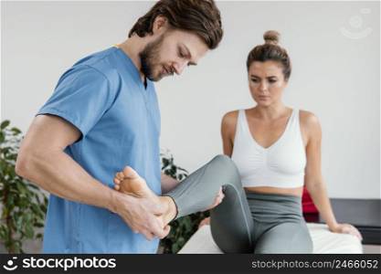 male osteopathic therapist checking female patient s leg movement