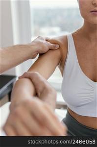male osteopathic therapist checking female patient s shoulder