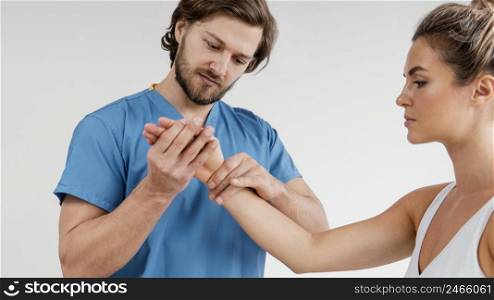 male osteopathic therapist checking female patient s wrist
