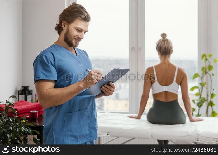 male osteopathic therapist with clipboard female patient office