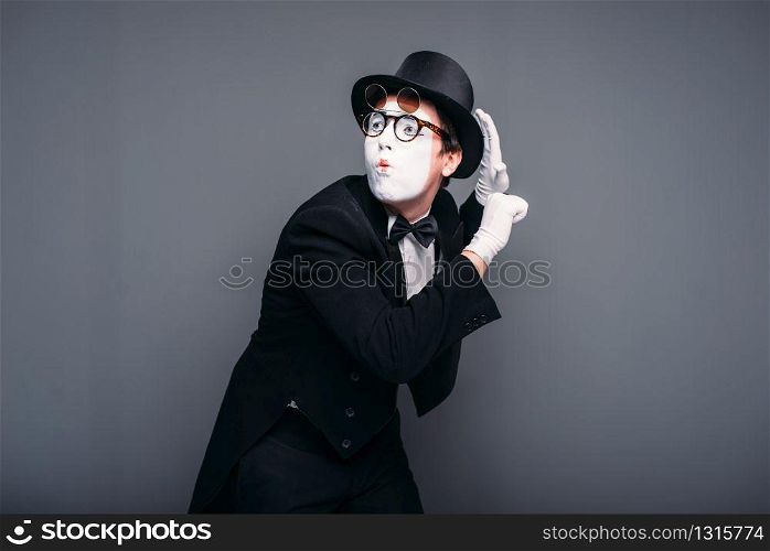 Male pantomime actor fun performing. Mime in suit, gloves, glasses, make-up mask and hat. April fools day concept. Male pantomime actor fun performing