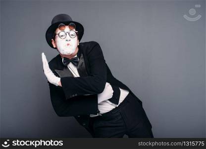 Male pantomime actor fun performing. Mime in suit, gloves, glasses, make-up mask and hat. April fools day concept. Male pantomime actor fun performing